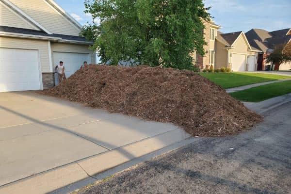 A pile of natural mulch in a driveway