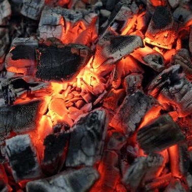 Firewood is burning in a firepit.